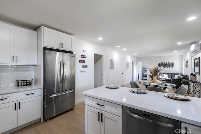 35414 Date Ave, Yucaipa, CA 92399 - kitchen featuring appliances with stainless steel finishes, a wall mounted air conditioner, open floor plan, light wood-type flooring, and light countertops