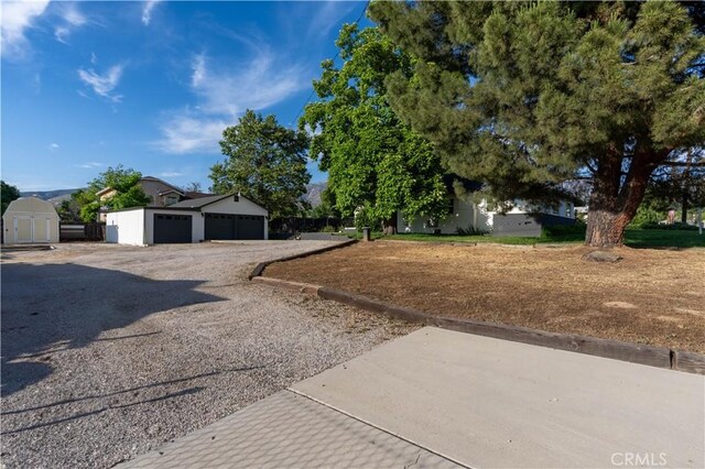 35414 Date Ave, Yucaipa, CA 92399 - view of yard featuring gravel driveway, a detached garage, and a storage shed