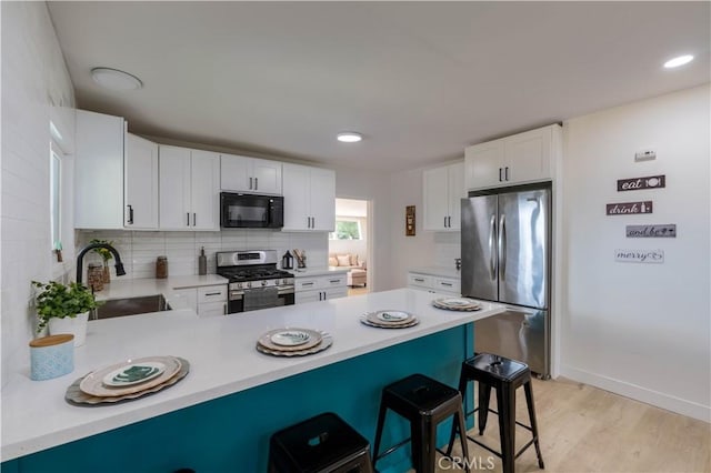 35414 Date Ave, Yucaipa, CA 92399 - kitchen featuring stainless steel appliances, a peninsula, light countertops, and a kitchen breakfast bar