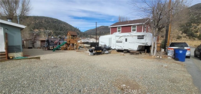 view of yard with a playground and a mountain view