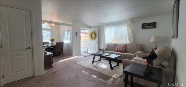 carpeted living room with an inviting chandelier