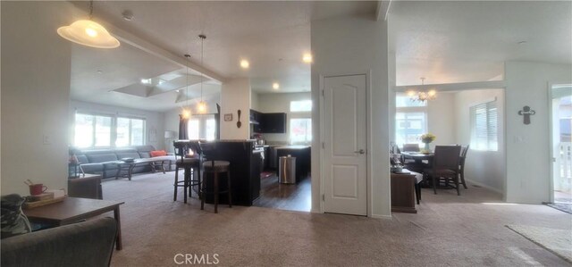 kitchen featuring carpet flooring, pendant lighting, a breakfast bar area, and vaulted ceiling