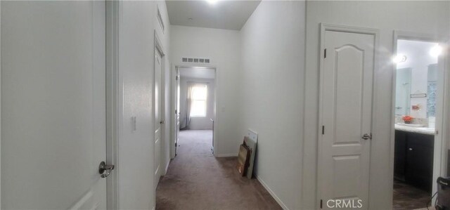 hall with dark colored carpet