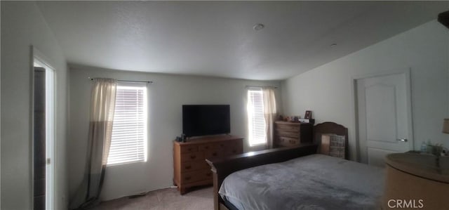 bedroom with light colored carpet and vaulted ceiling