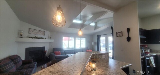 kitchen with light stone countertops, french doors, black range oven, hanging light fixtures, and lofted ceiling