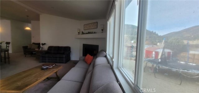 living room featuring a fireplace, a mountain view, plenty of natural light, and lofted ceiling