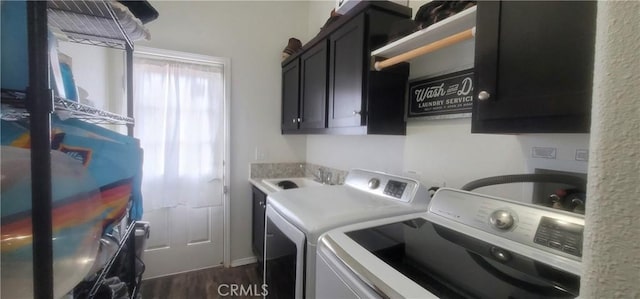 laundry area featuring cabinets, dark hardwood / wood-style flooring, washer and dryer, and sink