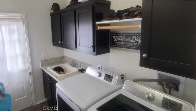 clothes washing area featuring washer and clothes dryer, cabinets, and sink