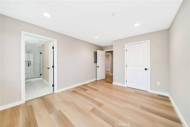 unfurnished bedroom featuring connected bathroom and light hardwood / wood-style flooring