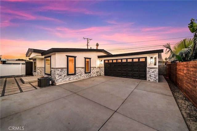 view of front of property featuring cooling unit and a garage