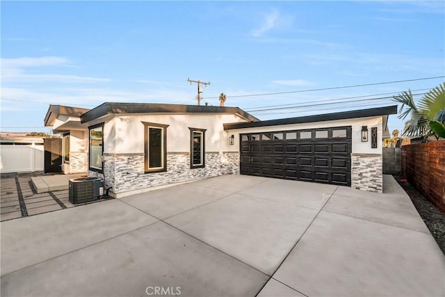 view of front of property with central air condition unit and a garage