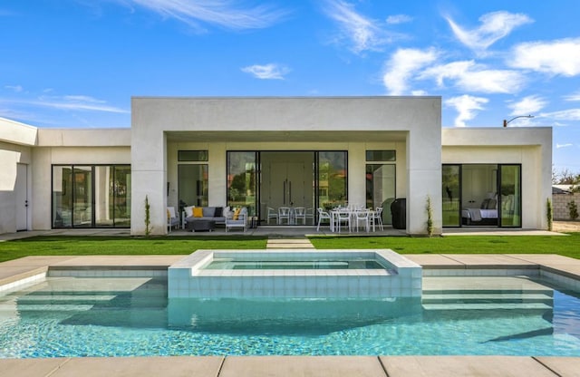 back of house with an in ground hot tub and a lawn