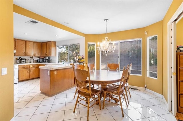 tiled dining space with an inviting chandelier