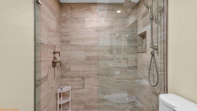 bathroom with toilet and tiled shower