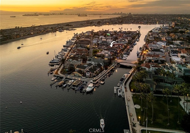 aerial view at dusk featuring a water view