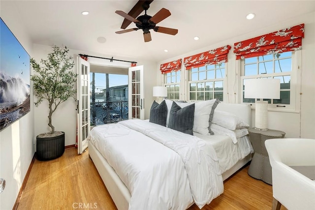 bedroom with hardwood / wood-style floors, multiple windows, and ceiling fan