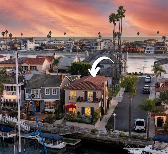 aerial view at dusk featuring a water view