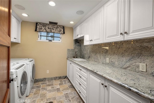 laundry room with cabinets, independent washer and dryer, and sink