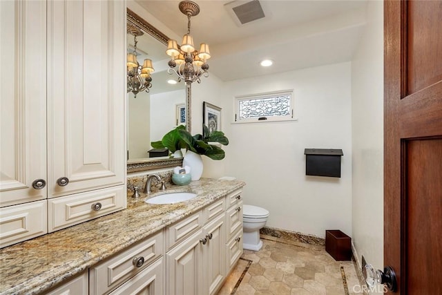 bathroom featuring a chandelier, vanity, and toilet