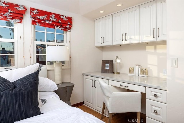 bedroom featuring built in desk and wood-type flooring