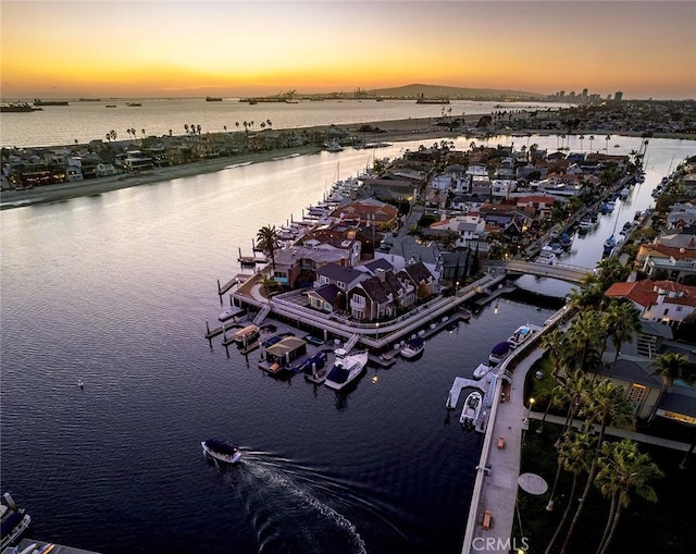 aerial view at dusk featuring a water view