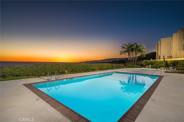 pool at dusk with a patio