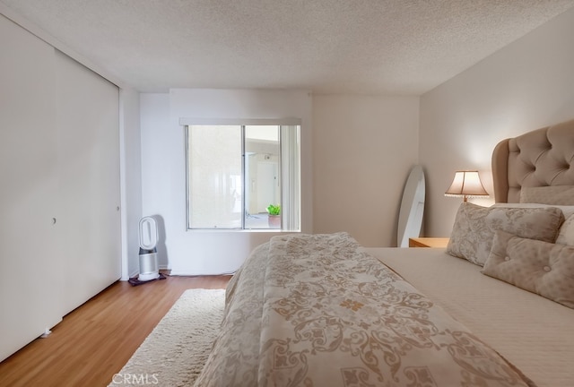 bedroom with wood-type flooring and a textured ceiling