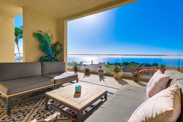 balcony with a water view and an outdoor hangout area