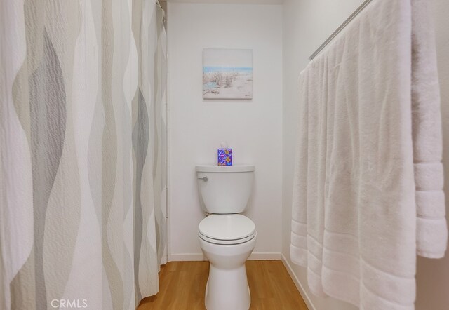 bathroom with hardwood / wood-style flooring and toilet