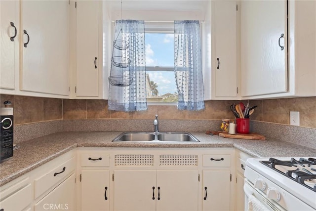 kitchen featuring white cabinetry, sink, decorative backsplash, and white gas range oven