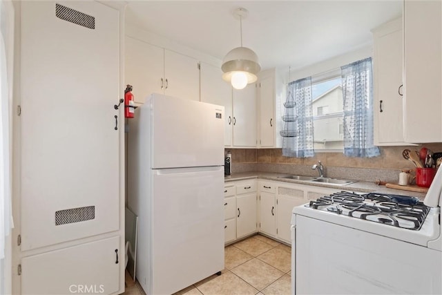 kitchen featuring sink, light tile patterned floors, white appliances, decorative backsplash, and white cabinets