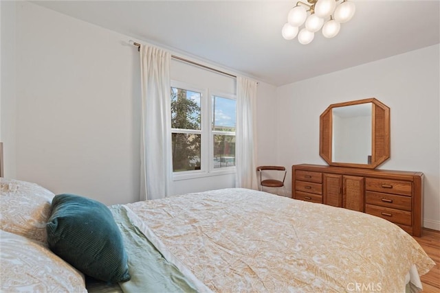 bedroom with an inviting chandelier and hardwood / wood-style floors