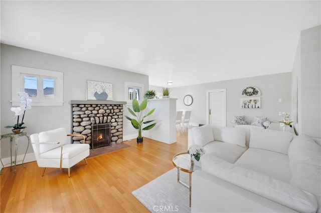 living room featuring hardwood / wood-style floors and a stone fireplace