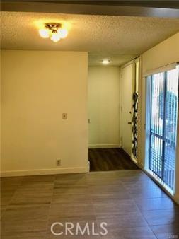 empty room featuring dark hardwood / wood-style flooring and a textured ceiling