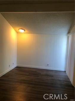 spare room featuring dark wood-type flooring