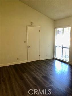 empty room with lofted ceiling and dark wood-type flooring