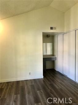 interior space with dark hardwood / wood-style floors and vaulted ceiling