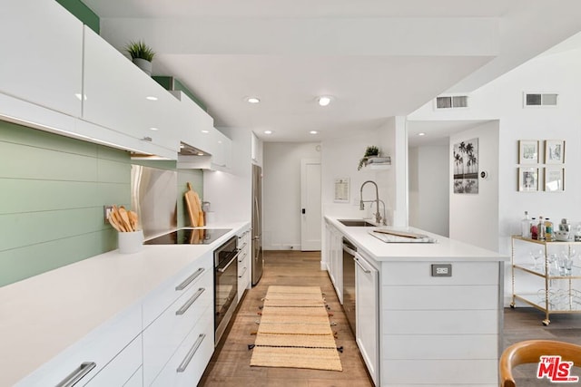 kitchen featuring white cabinetry, light wood-type flooring, and appliances with stainless steel finishes