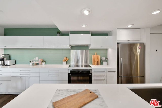 kitchen with decorative backsplash, dark wood-type flooring, white cabinets, and stainless steel appliances