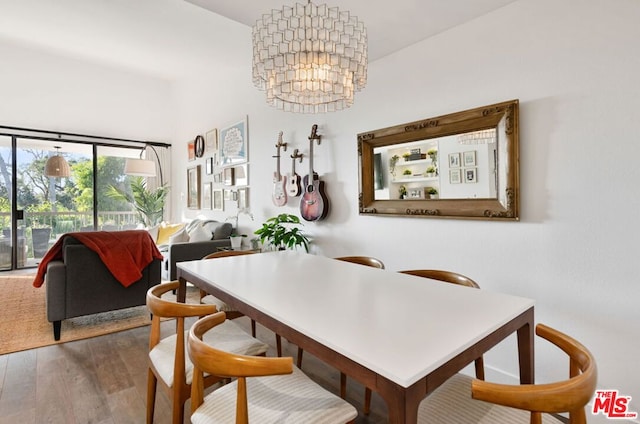 dining space with wood-type flooring and an inviting chandelier