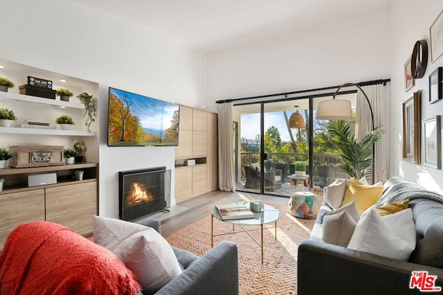 living room with a towering ceiling and light hardwood / wood-style floors