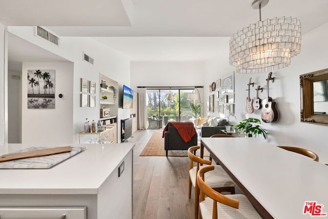 dining space featuring a notable chandelier and light wood-type flooring