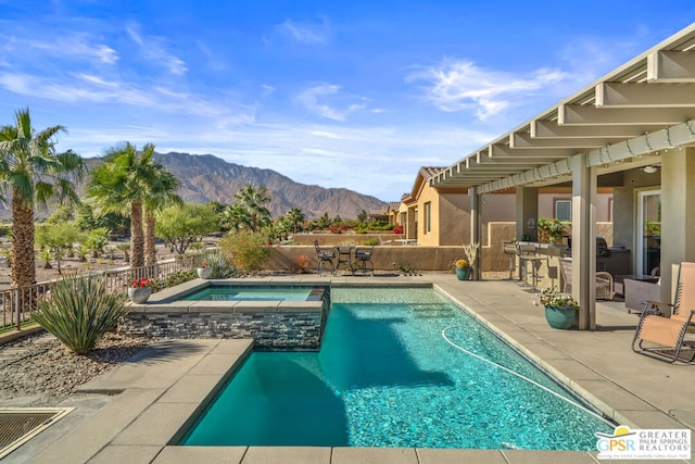 view of pool featuring a mountain view, a patio, and an in ground hot tub