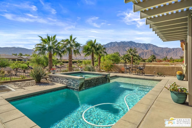 view of swimming pool with a mountain view, a patio, and an in ground hot tub