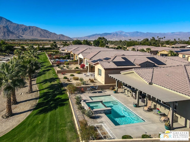 view of pool featuring a mountain view, a patio, and an in ground hot tub