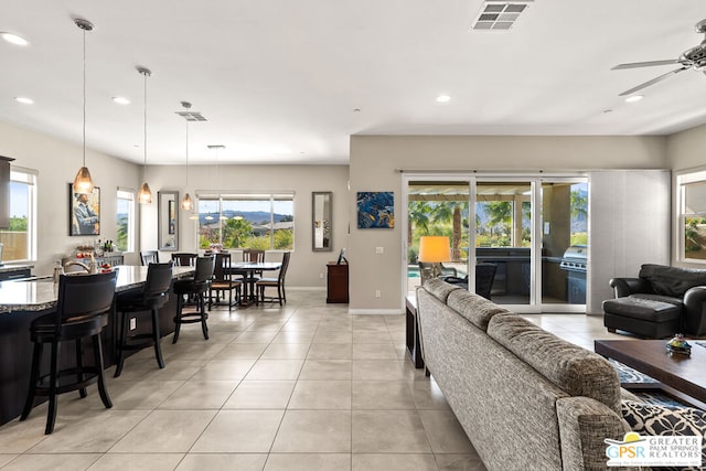 tiled living room with ceiling fan and a healthy amount of sunlight