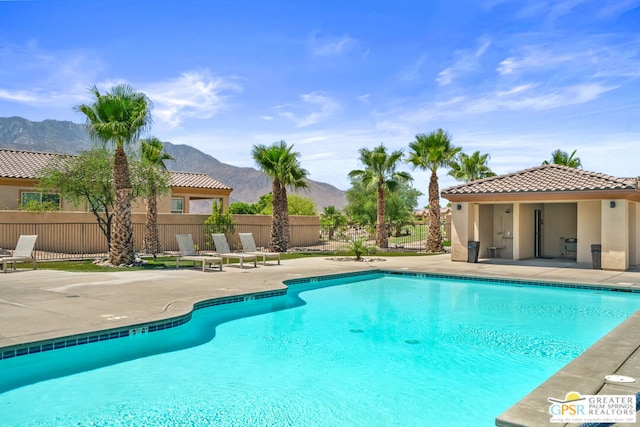 view of swimming pool with a mountain view and a patio