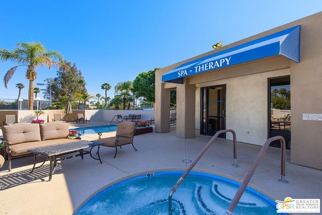 view of swimming pool featuring a hot tub and a patio area