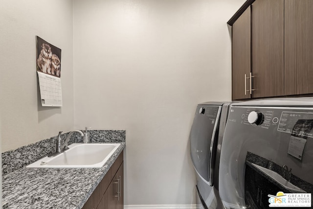 laundry room with washer and dryer, sink, and cabinets