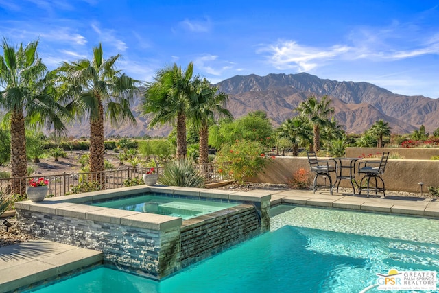 view of pool featuring a mountain view and an in ground hot tub